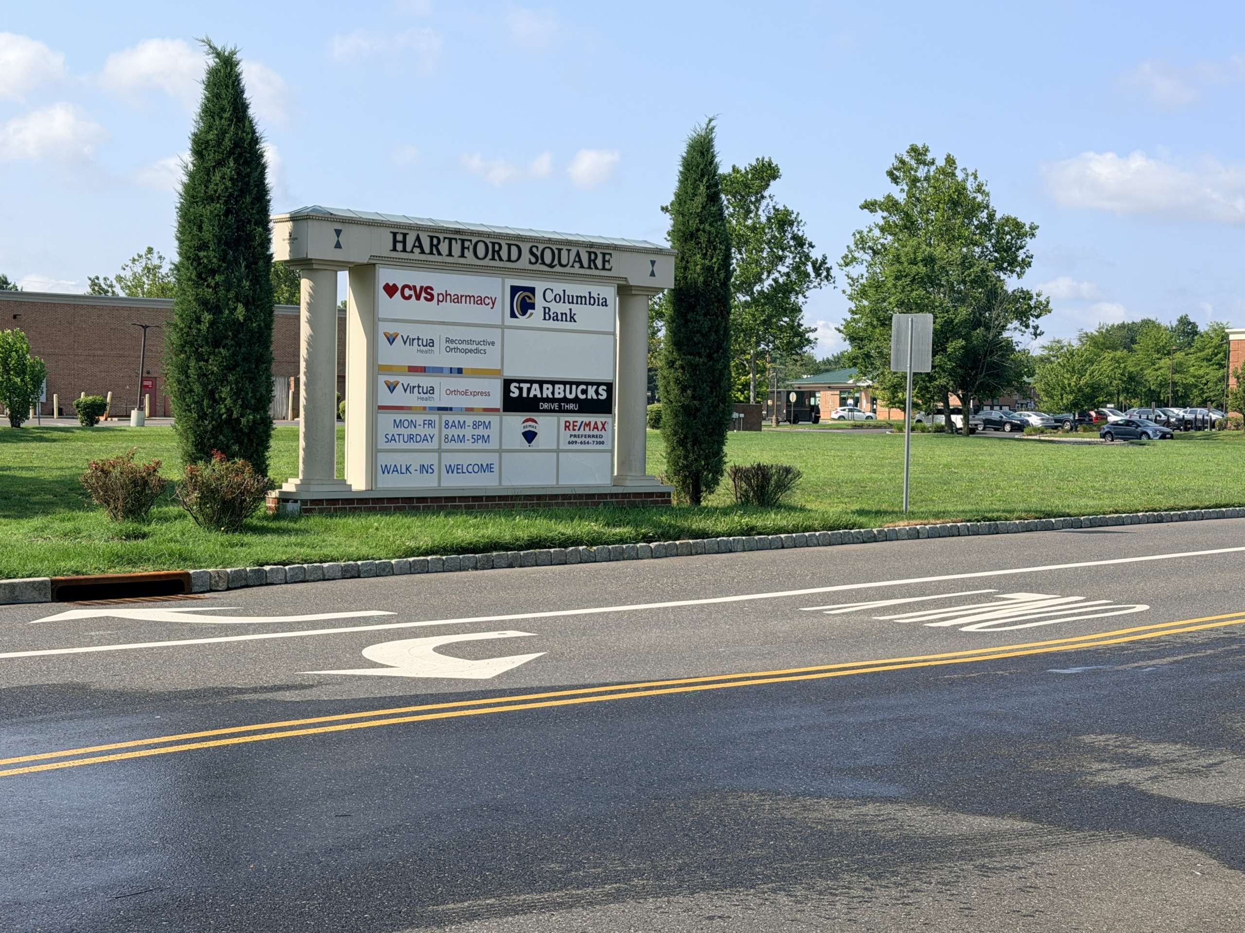 Hartford Square shopping center sign displaying CVS Pharmacy, Columbia Bank, Starbucks drive-thru, and other tenants in a landscaped lot.