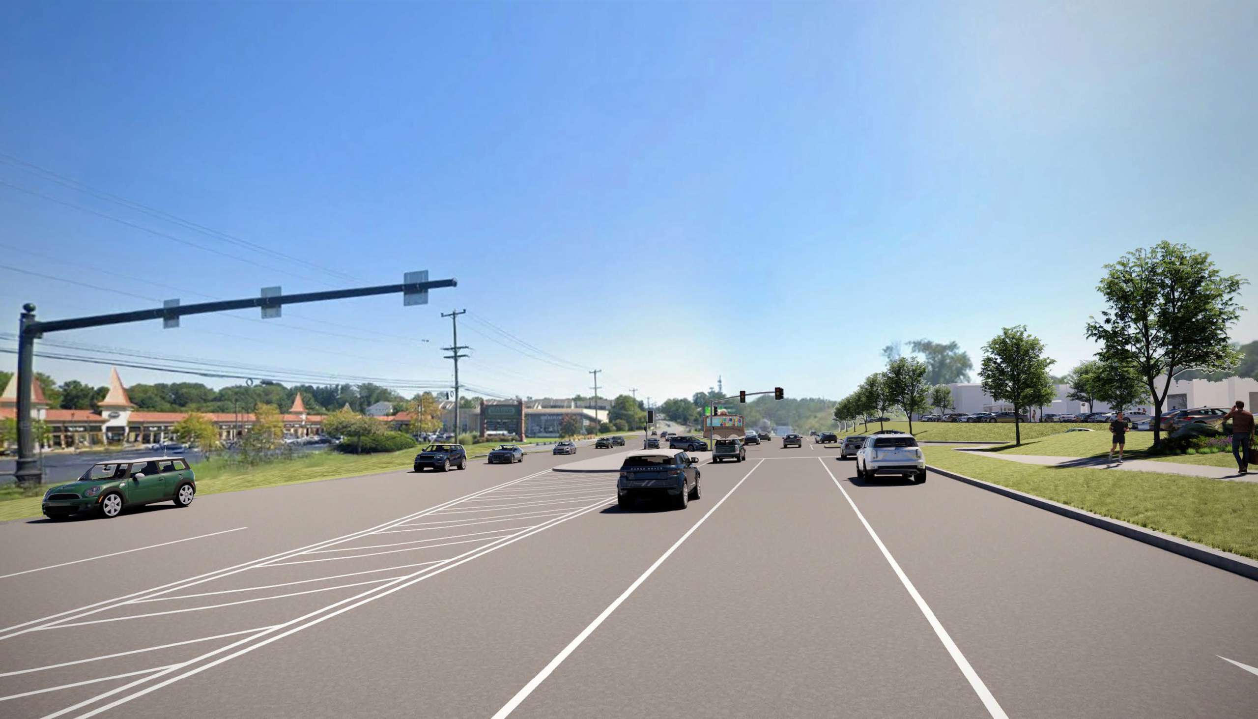 Wide urban road at a signalized intersection with multiple lanes, cars in both directions, and trees and buildings along the right side under a clear blue sky.