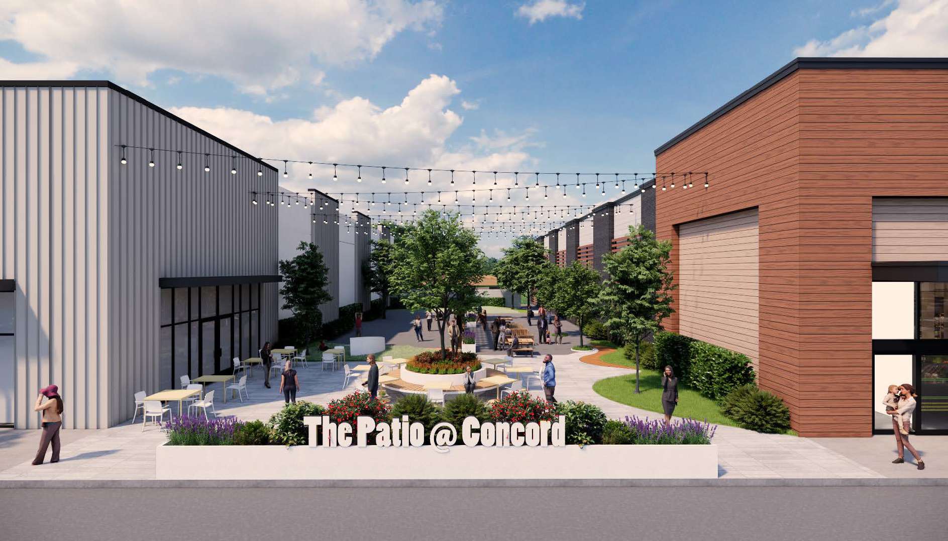 Outdoor courtyard between modern industrial buildings with string lights and trees; foreground sign reads 'The Patio @ Concord'