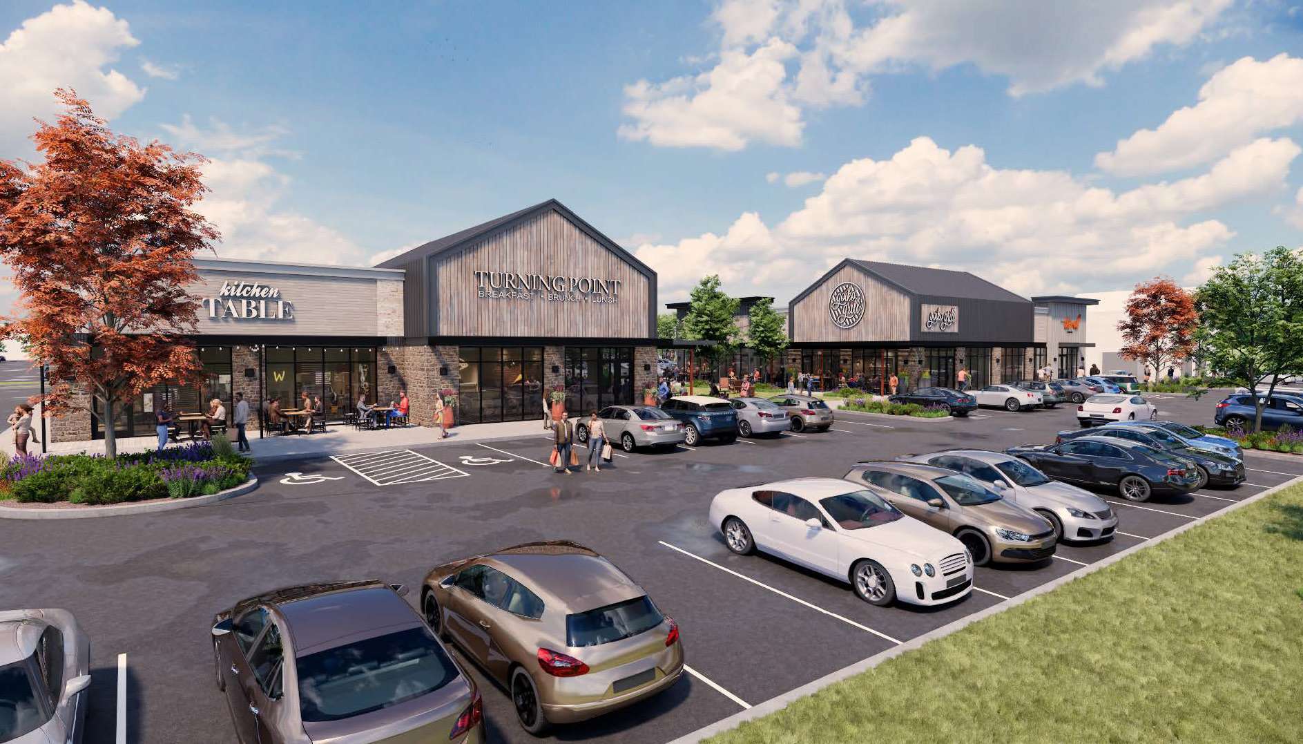 Exterior view of a shopping center with dining tenants like Kitchen Table and Turning Point, in a parking lot with cars on a sunny day