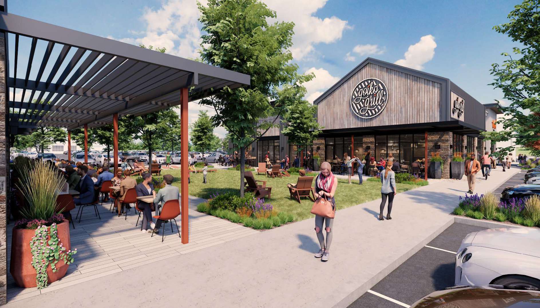 Outdoor dining area with patrons at tables under a metal pergola beside a wooden restaurant building labeled Goiko Grill and greenery around.